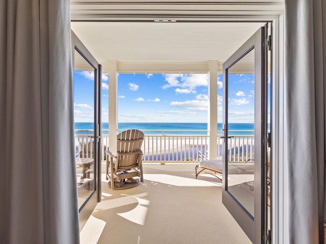 balcony featuring a water view and a view of the beach