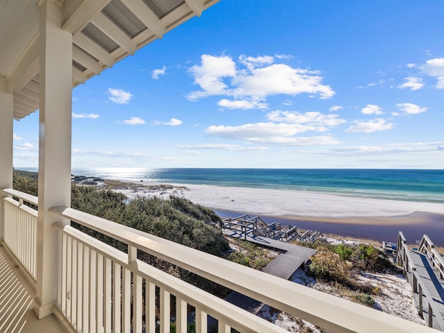 balcony featuring a water view and a beach view