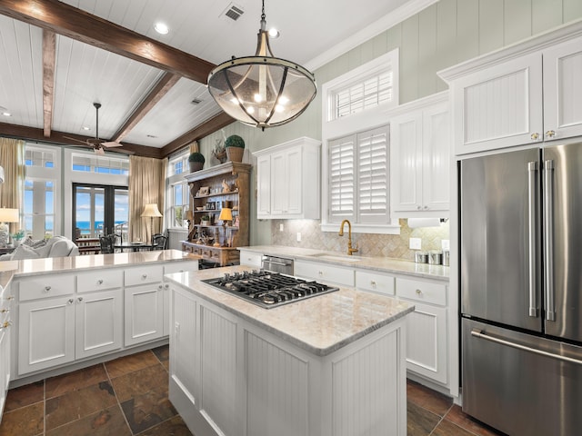 kitchen featuring white cabinetry, appliances with stainless steel finishes, a kitchen island, pendant lighting, and beam ceiling