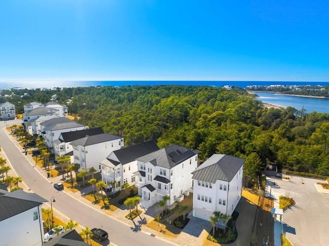 bird's eye view featuring a forest view, a water view, and a residential view