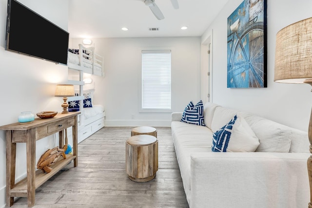 living room featuring hardwood / wood-style floors and ceiling fan