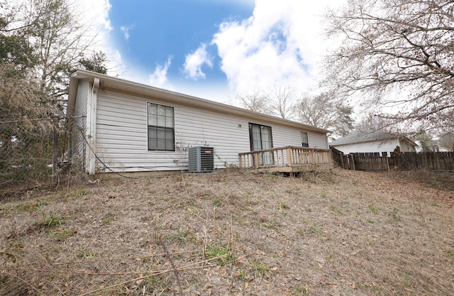 rear view of house with central AC and a deck