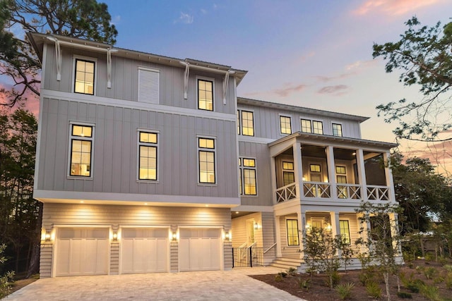 3232 W County Highway 30a, Santa Rosa Beach, FL 32459 - view of front facade featuring a garage, decorative driveway, board and batten siding, and a porch