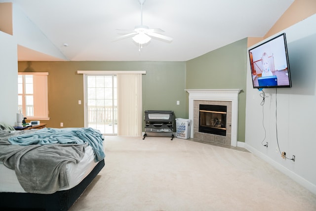 carpeted bedroom with lofted ceiling, a tiled fireplace, access to outside, and ceiling fan