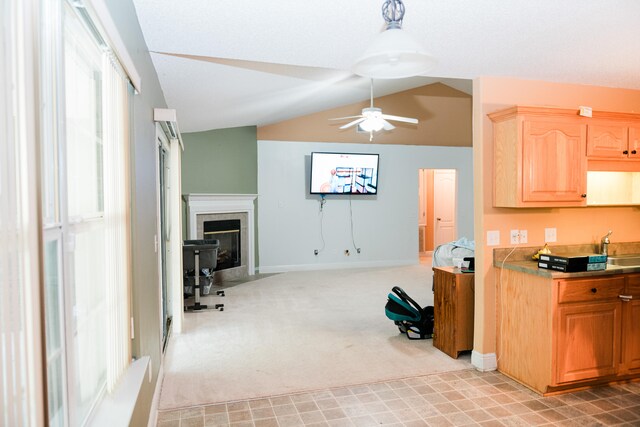 kitchen with ceiling fan, lofted ceiling, sink, and light carpet