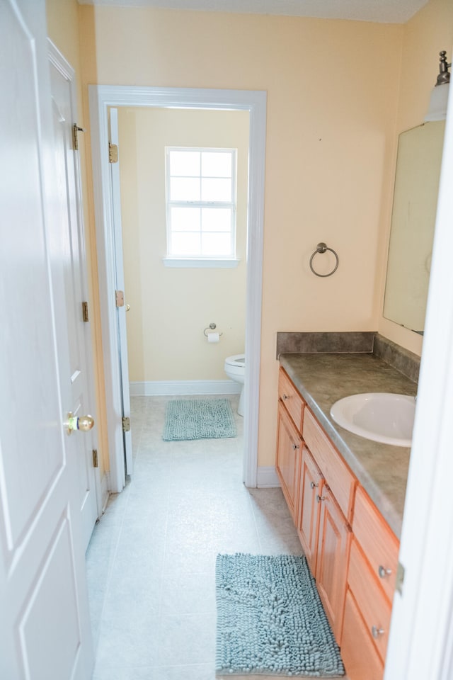 bathroom featuring vanity, tile patterned flooring, and toilet