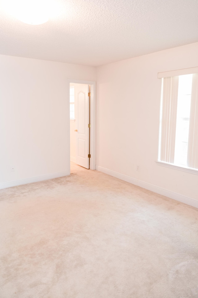 carpeted spare room featuring a textured ceiling