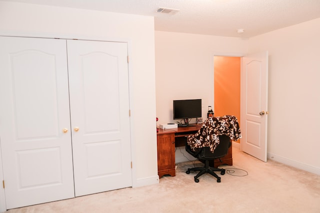 carpeted office featuring a textured ceiling