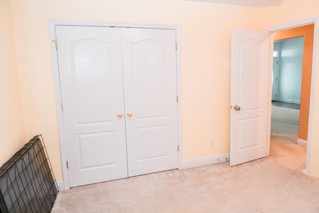 unfurnished bedroom with light carpet and a closet