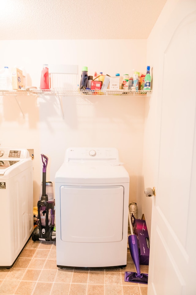 washroom featuring light tile patterned floors and washer and clothes dryer