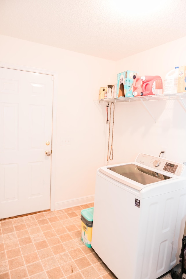 washroom featuring washer / dryer and a textured ceiling