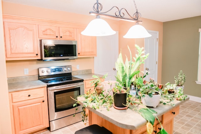 kitchen featuring hanging light fixtures, light brown cabinets, and appliances with stainless steel finishes