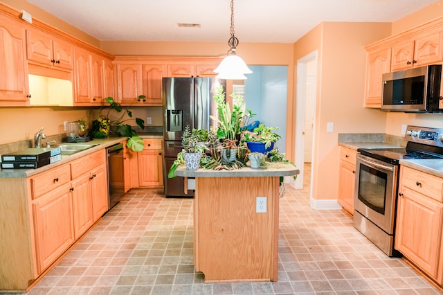 kitchen with light brown cabinetry, sink, decorative light fixtures, a center island, and stainless steel appliances