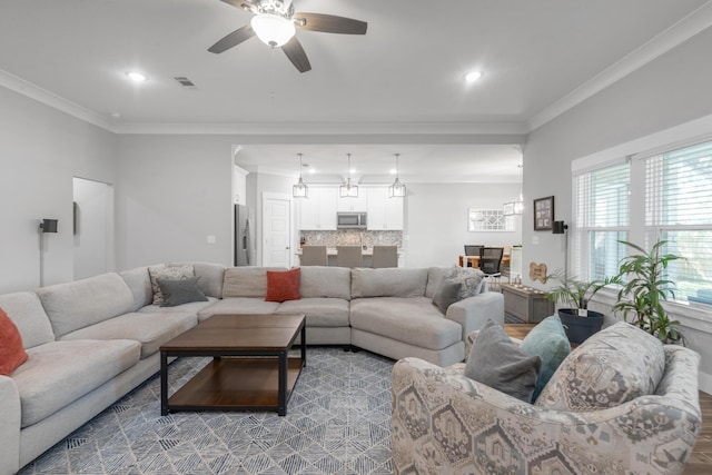 living area with visible vents, ceiling fan, ornamental molding, wood finished floors, and recessed lighting