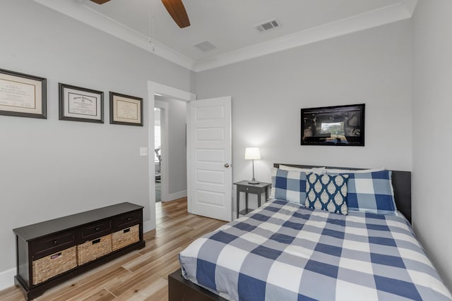 bedroom with light wood-style flooring, crown molding, visible vents, and a ceiling fan