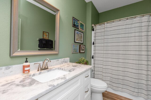 bathroom with a shower with shower curtain, vanity, and toilet