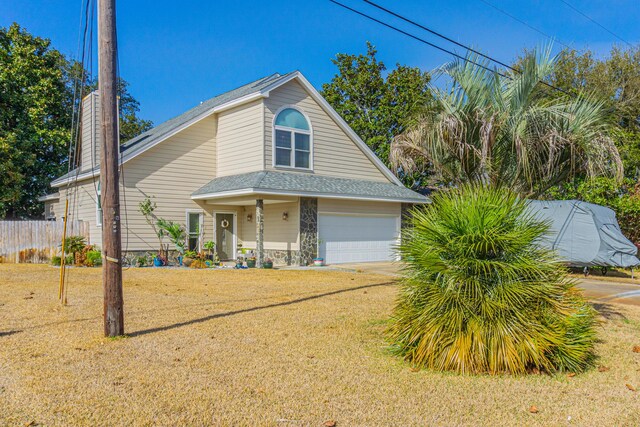 view of front of house featuring a garage, a front yard, and covered porch