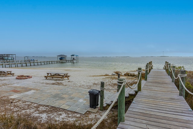 dock area with a water view and a view of the beach