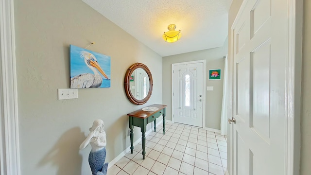 entryway with light tile patterned flooring and a textured ceiling