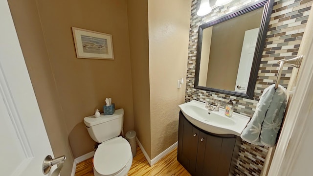 bathroom featuring tasteful backsplash, vanity, hardwood / wood-style floors, and toilet