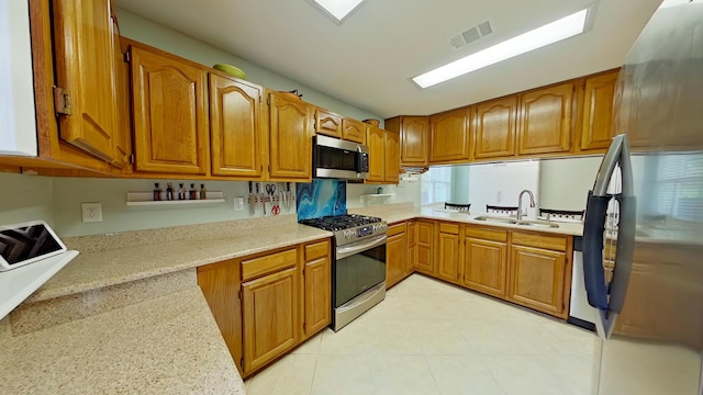 kitchen with stainless steel appliances, sink, and light tile patterned floors