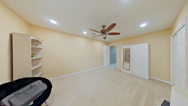 interior space with light carpet and ceiling fan