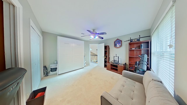 carpeted living room with ceiling fan