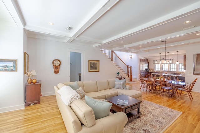 living room with beam ceiling, coffered ceiling, and light hardwood / wood-style floors