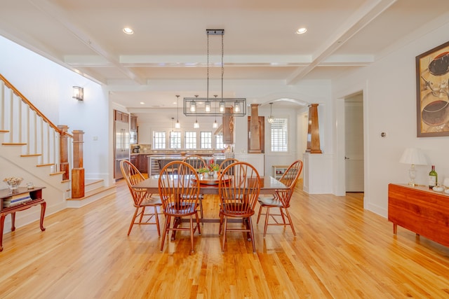 dining space featuring beamed ceiling, coffered ceiling, and light hardwood / wood-style floors