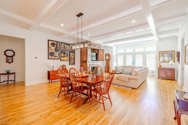 dining space with beamed ceiling, coffered ceiling, and light wood-type flooring