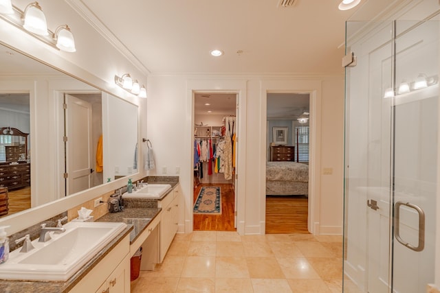 bathroom featuring tile patterned flooring, vanity, crown molding, and a shower with door