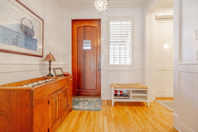 entryway featuring ornamental molding and light hardwood / wood-style flooring