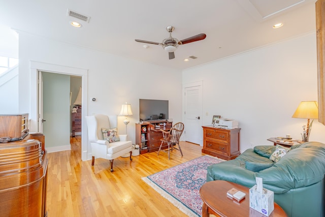 living room with crown molding, light hardwood / wood-style floors, and ceiling fan