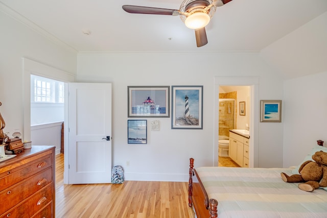 bedroom with crown molding, connected bathroom, ceiling fan, and light hardwood / wood-style flooring