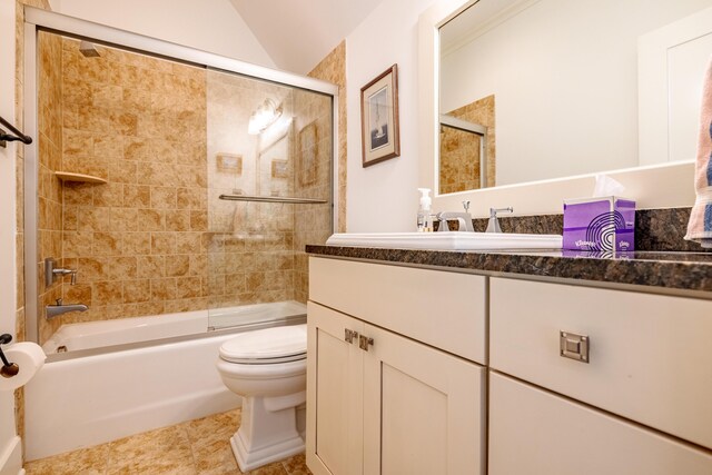 full bathroom featuring lofted ceiling, combined bath / shower with glass door, vanity, tile patterned floors, and toilet