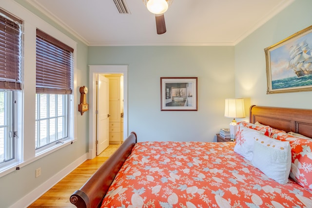 bedroom featuring connected bathroom, light hardwood / wood-style flooring, ornamental molding, and ceiling fan