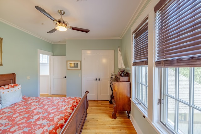 bedroom featuring crown molding, light hardwood / wood-style flooring, a closet, and ceiling fan