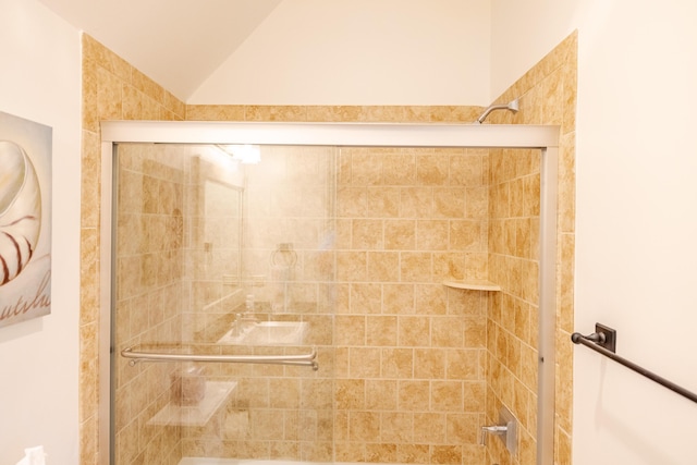 bathroom with walk in shower and lofted ceiling