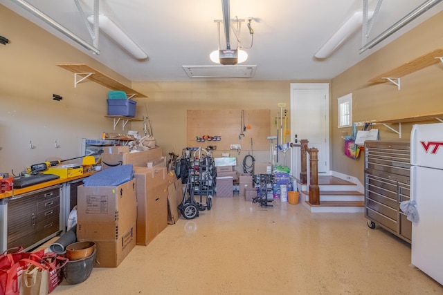 garage with a garage door opener, a workshop area, and white refrigerator