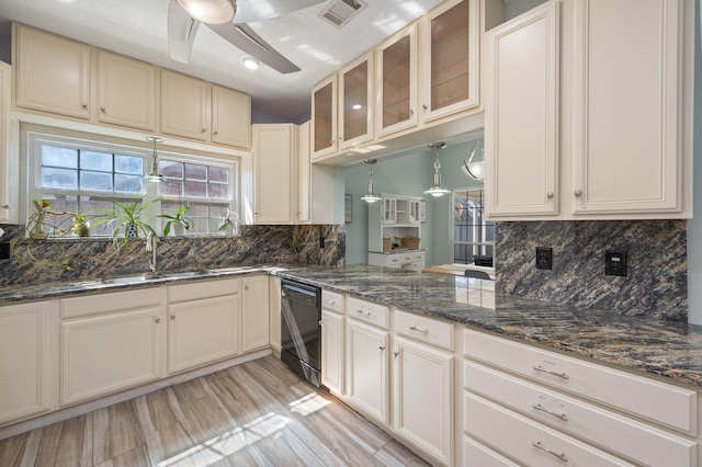 kitchen featuring black dishwasher, visible vents, ceiling fan, glass insert cabinets, and decorative light fixtures