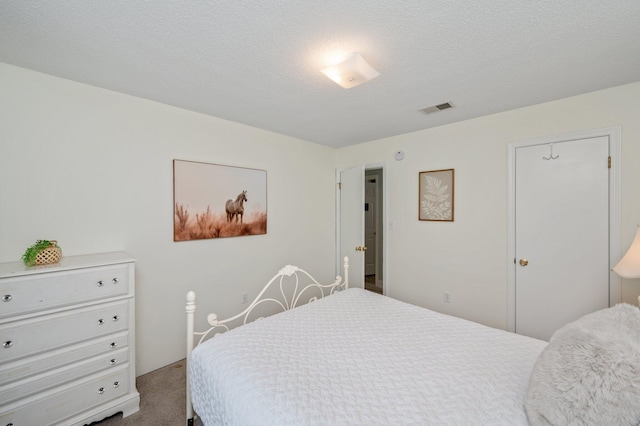 carpeted bedroom with visible vents and a textured ceiling