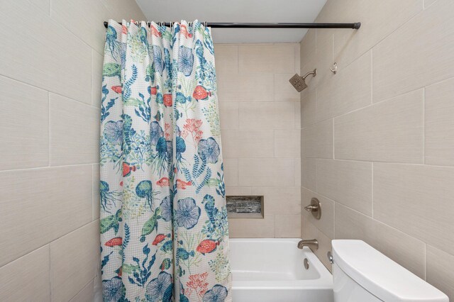 bathroom featuring toilet and shower / bath combo with shower curtain