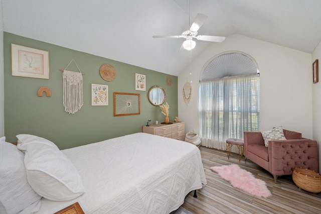 bedroom with lofted ceiling, a ceiling fan, and light wood-style floors