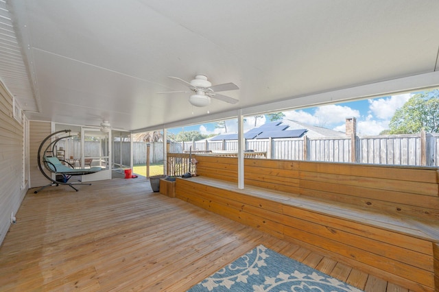 unfurnished sunroom featuring ceiling fan