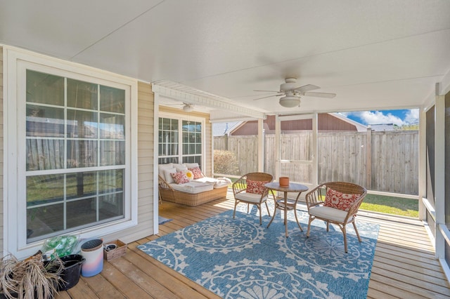 sunroom featuring plenty of natural light and a ceiling fan