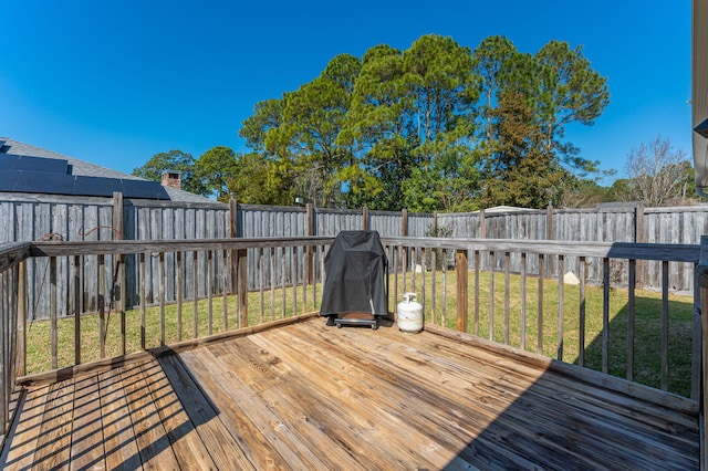 wooden terrace featuring a fenced backyard and a yard