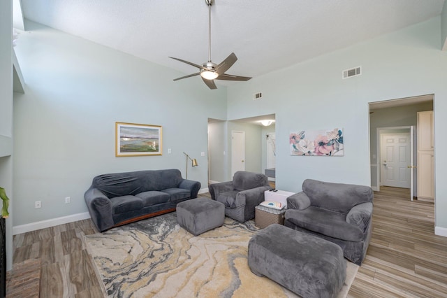 living room featuring baseboards, visible vents, and wood finished floors