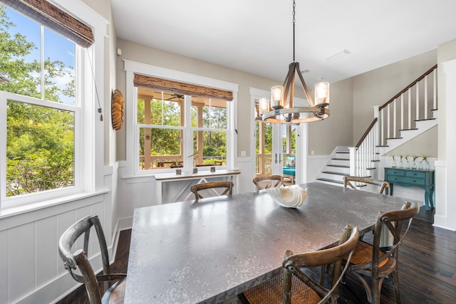 dining area with dark hardwood / wood-style flooring and an inviting chandelier