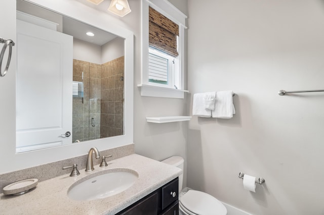 bathroom featuring vanity, toilet, and a shower with shower door