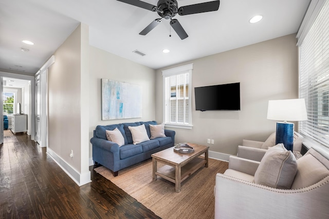 living room with dark hardwood / wood-style flooring and ceiling fan